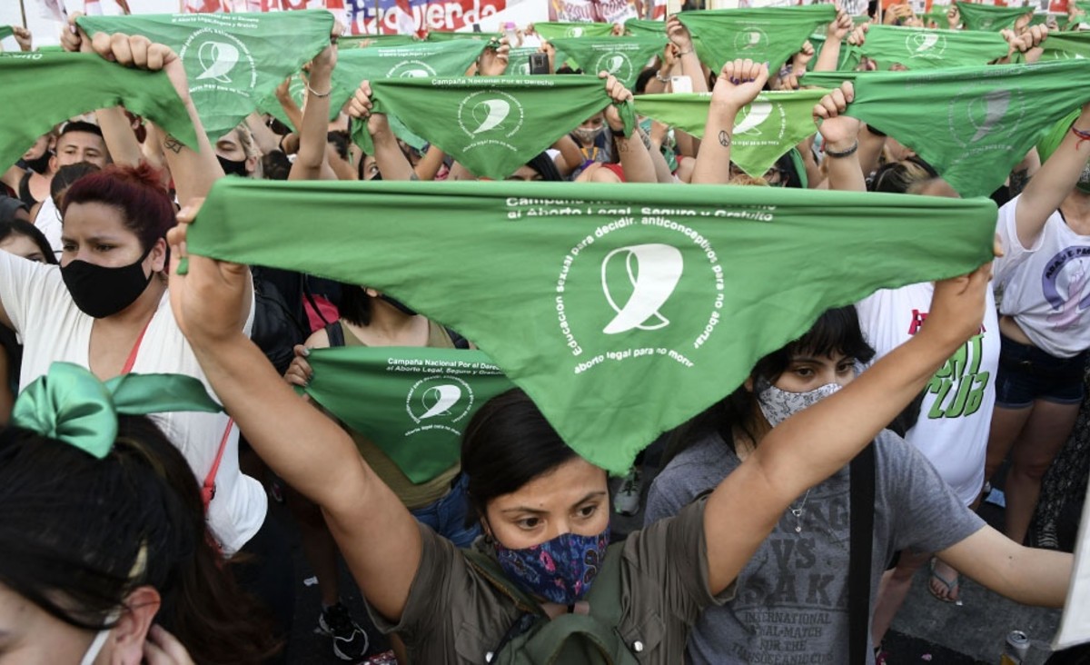 Imágenes de mujeres extendiendo sus pañuelos verdes